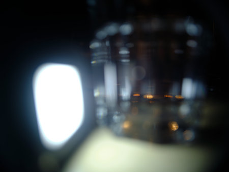 Blurry light effects, of out of focus glasses, in front of a dark background