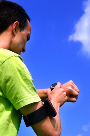 Sporting boy training with the chronometer and the mp3 player during a sunshine dayの写真素材