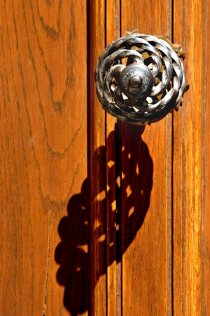 Old-style handle on an orange wooden doorの写真素材