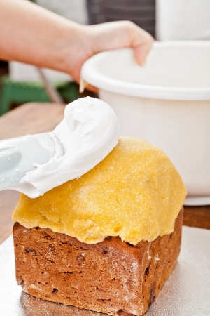 Spreading cream on christmas cake with a spatulaの写真素材