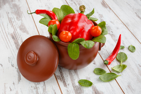 Traditional crock pot with row food fresh vegetablesの写真素材