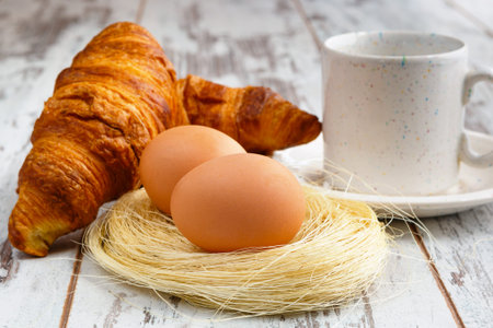 Milk, eggs, corissant on white wooden background