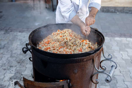 open fire on wood in a large cauldron for cooking pilafの写真素材