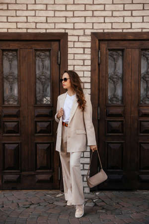 young woman in white pantsuit and white t-shirt in city locationの写真素材