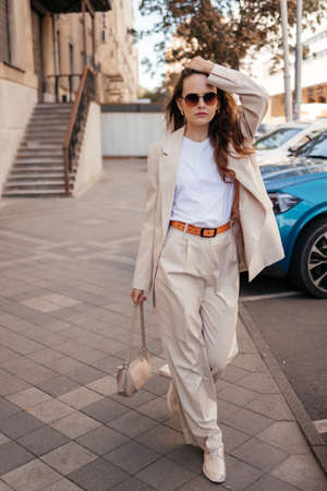 young woman in white pantsuit and white t-shirt in city locationの写真素材