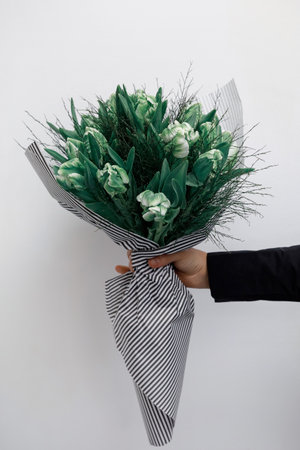 Girl in a black dress holds a bouquet of roses on a white backgroundの写真素材