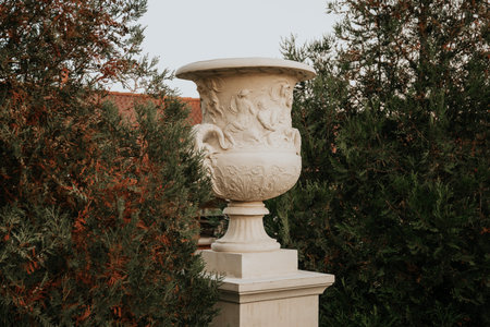 large white stone flowerpot against the backdrop of the greenery of the parkの写真素材