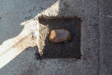 laying the first stone in the foundation of a house under construction against a background of...