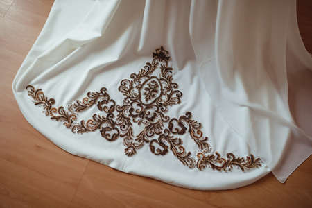 embroidery with gold and white beads and glass beads on the bride's wedding dress close-upの写真素材