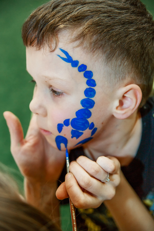 Child with a picture of scorpion on his face as a child's make-upの写真素材
