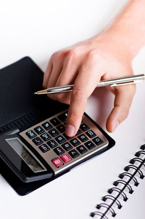 Hand with pen is typing numbers on calculatorの写真素材