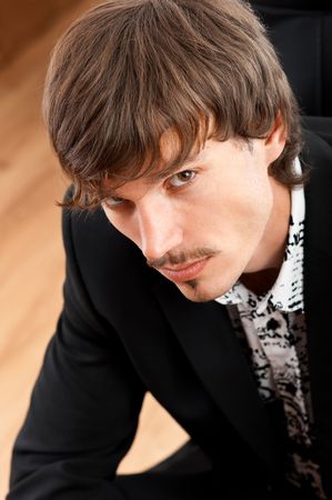 Portrait of serious young businessman looking at camera in office environmentの写真素材