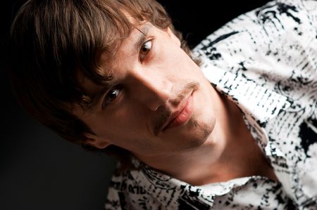 Portrait of stylish guy looking at camera against black backgroundの写真素材