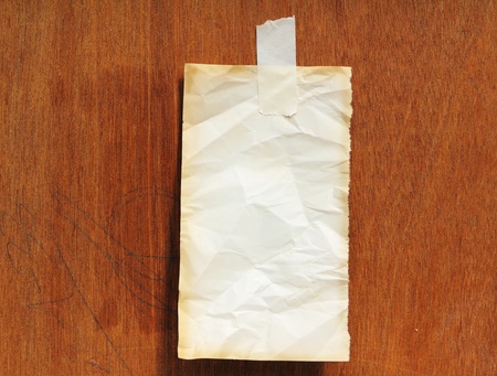 Old note paper on woodの写真素材