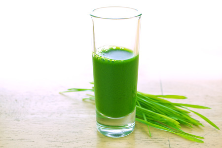 Wheathgrass juice on wood backgroundの写真素材