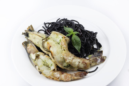 Black spaghetti with shrimp isolated on whiteの写真素材