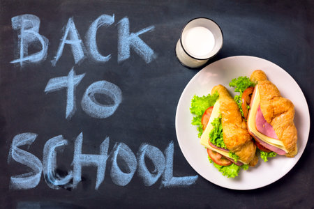Still life with Sandwich and milk on blackboard with back to school on background