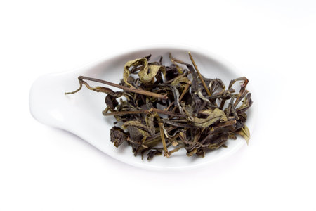 Dried black tea in spoon isolated on white background 