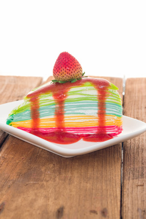 Rainbow crepe cake with strawberry juice and fresh strawberry on topの写真素材
