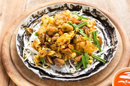 Crisp fried mussel pancake on woodの写真素材