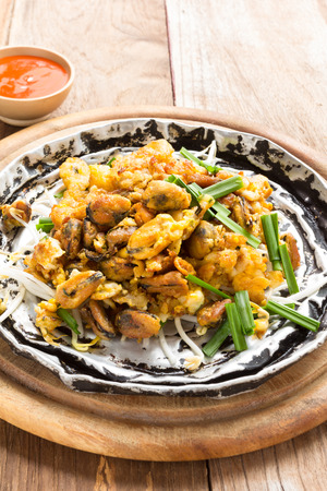 Crisp fried mussel pancake on old woodの写真素材
