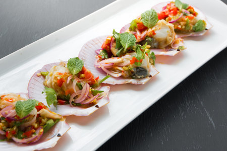 Spicy salad with deep-sea scallops in Thai style on black background