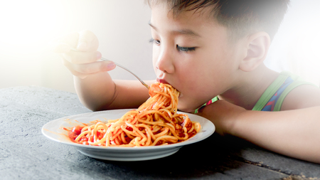 Asian boy eating spaghettiの写真素材