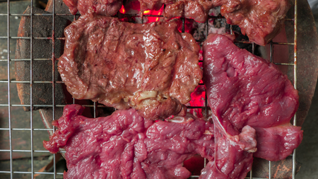 beef steak cooking over flaming grillの写真素材
