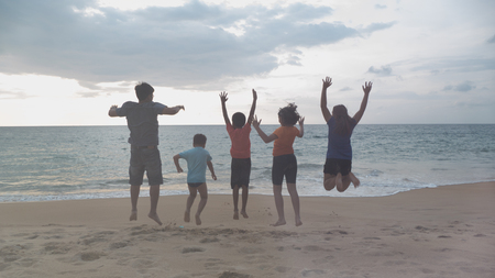 Funny family jumpy on the beachの写真素材