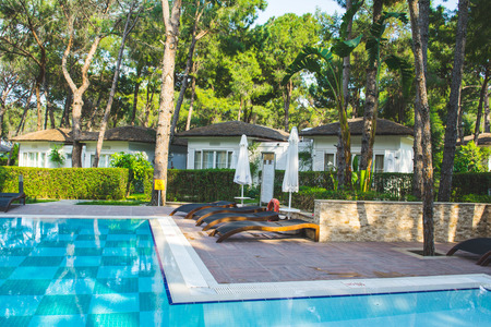 Antalya, Turkey - 9 May 2018: Pull area and white villas in luxury turkish resort surrounded by pine treesのeditorial素材
