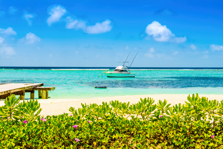 Lhaviyani Atoll, Maldives - 30 July 2018: Boat in the Indian Ocean on the background with a tropical island landscape and a sandy beachのeditorial素材