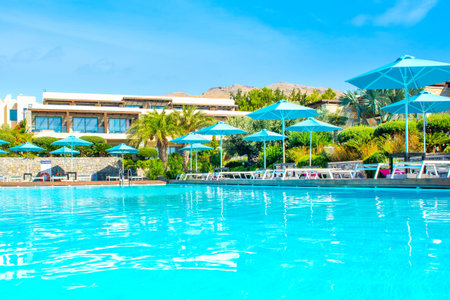 Rhodes, Greece - 18 July 2019: Outdoor pool area in a luxury hotel on the Rhodes island with sunbeds and umbrellasのeditorial素材