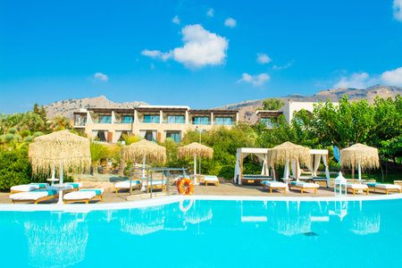 Rhodes, Greece - 18 July 2019: Outdoor pool area in a luxury hotel on the Rhodes island with sunbeds and umbrellasのeditorial素材