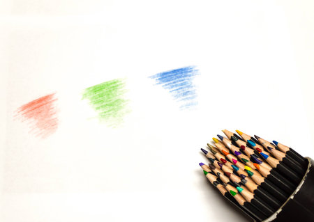 close up of spilled colored pencil container with red green and blue scribblesの写真素材