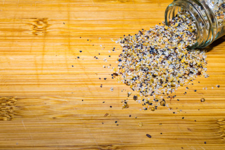 Spilled spice container on bamboo cutting boardの写真素材