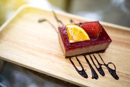 Delicious dessert. Strawberry and orange fruit cake placed on a wooden tray. Close up shot.の写真素材