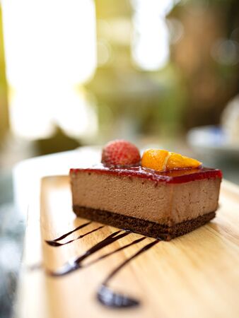 Delicious dessert. Strawberry and orange fruit cake placed on a wooden tray. Close up shot.の写真素材