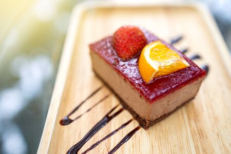 Delicious dessert. Strawberry and orange fruit cake placed on a wooden tray. Close up shot.の写真素材