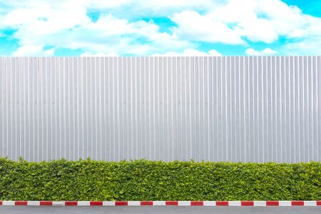 The aluminum wall used in the construction area. And there were trees beside the wall.の写真素材