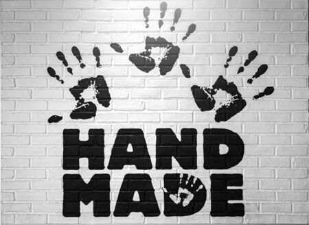 Hand marks or handprint by a slap and word hand made on a white brick wall.  abstract dirty background.の写真素材