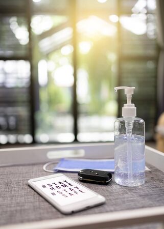 Gel bottles washing hands, car keys, mobile phones and a mask on the table.の写真素材