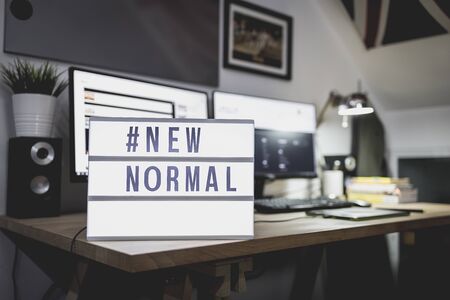 Light signs with text hashtag #NEW NORMAL on the working desk. Work from home. New normal concept. Social distancing.の写真素材