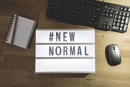 Top view of light signs with text hashtag #NEW NORMAL on the working desk. Work from home. New normal concept. Social distancing.の写真素材