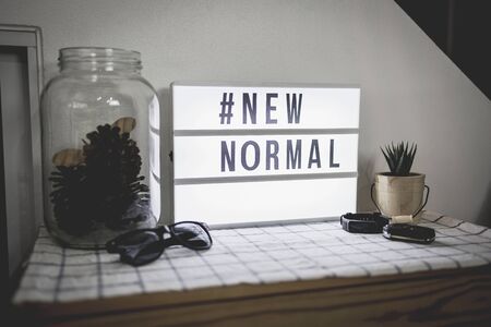 Light box signs with text hashtag #NEW NORMAL on cabinets and home decor. New normal concept. Social distancing.の写真素材