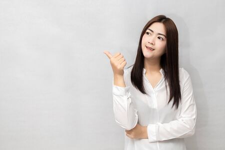 Long haired Asian woman is smiling happily. And thumbs up to show appreciation. on white background.の写真素材