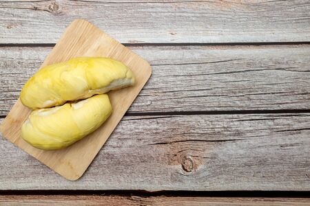 Durian on a wooden tray on an old wooden table. Durian is a summer fruit in Thailand, nicknamed the king of fruits.の写真素材