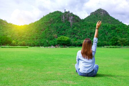 The back image is enjoying the holiday holidays and and watching beautiful view of woods and blue sky and clouds on vacation. Asian woman travel alone.の写真素材