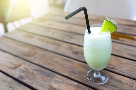 Melon smoothie in glasses with slices of melon on vintage  wooden table. Giving a feeling of sweet, cool, fresh.の写真素材