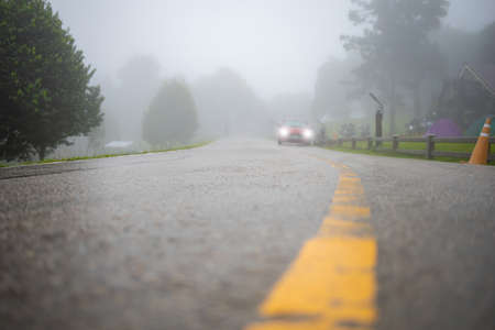 Wet road with car and fog in the morning after rain. Selective Focus.の写真素材