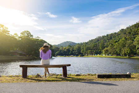 A woman is sitting alone by the lake.の写真素材